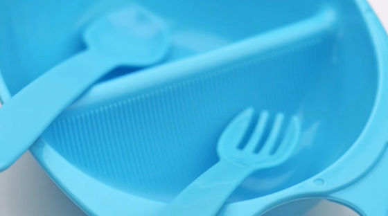 Plástico encima del cuenco del bebé de 3 meses con la bifurcación de la cuchara